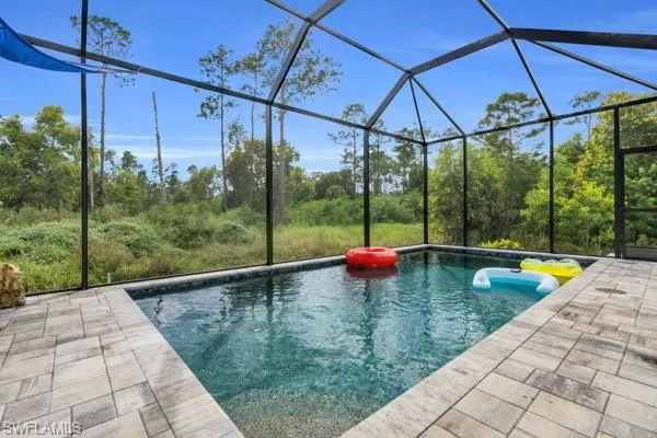 Swimming pool featuring glass enclosure and a sunroom