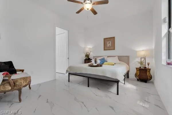 Bedroom with ceiling fan and light marble finish flooring