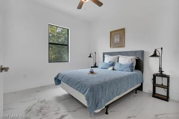 Bedroom featuring marble look tile flooring and ceiling fan