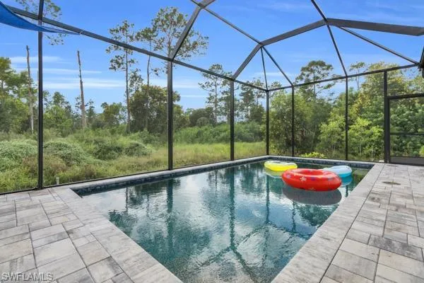 Outdoor pool featuring a sunroom and a lanai