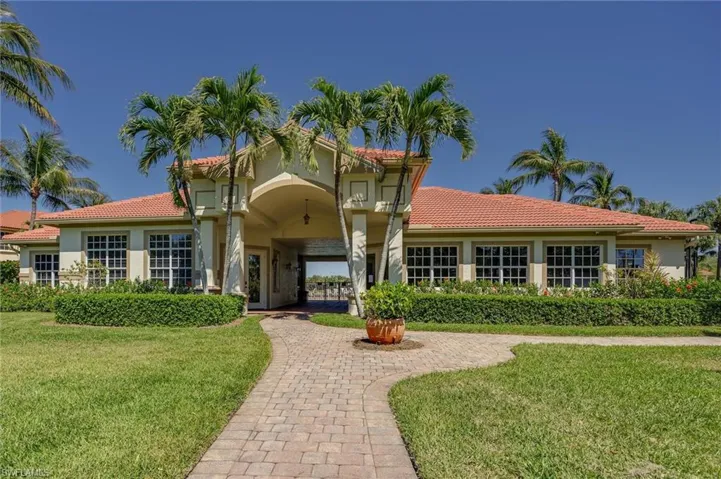 View of front of property featuring a tile roof, a front lawn, and stucco siding