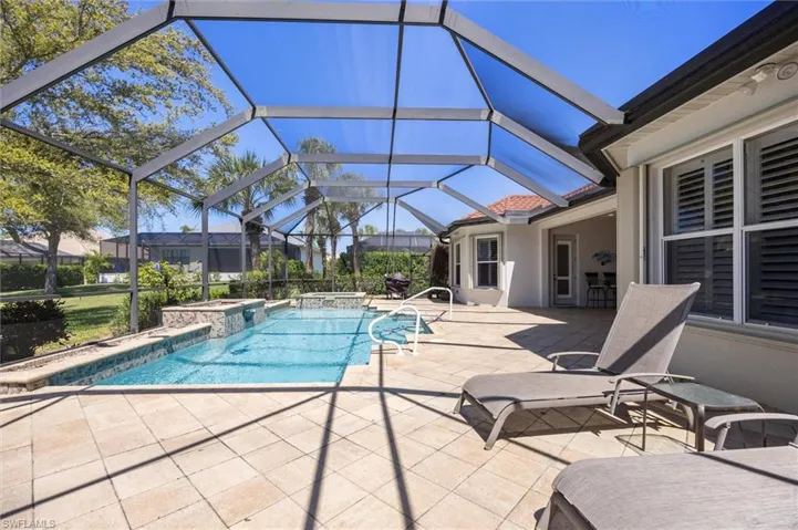 Combined pool / hot tub featuring a patio area, glass enclosure, and a sunroom