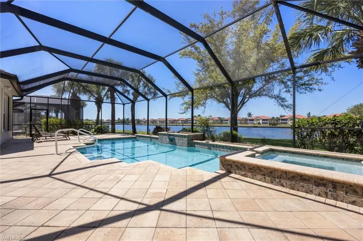 Combined pool / hot tub featuring a sunroom, a patio, a water view, a lanai, and a residential view