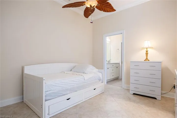 Bedroom featuring ensuite bath, a ceiling fan, ornamental molding, and light tile patterned floors