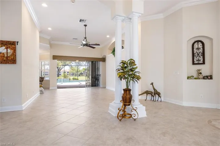 Spare room featuring ceiling fan, crown molding, decorative columns, recessed lighting, and light tile patterned flooring