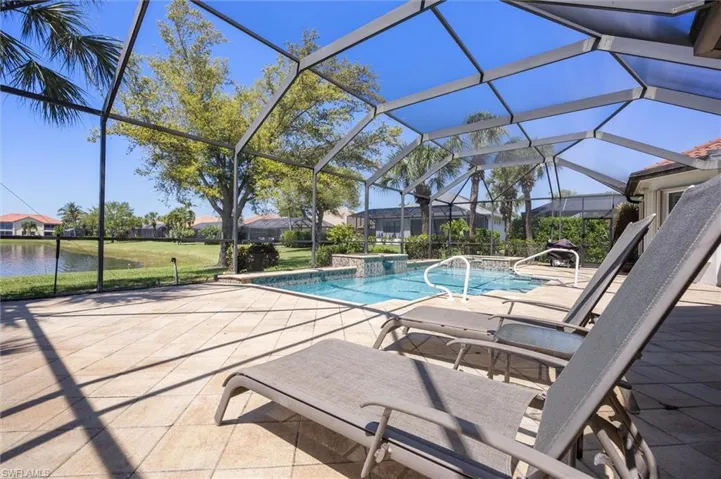 Swimming pool featuring a patio, glass enclosure, a jacuzzi, and a sunroom