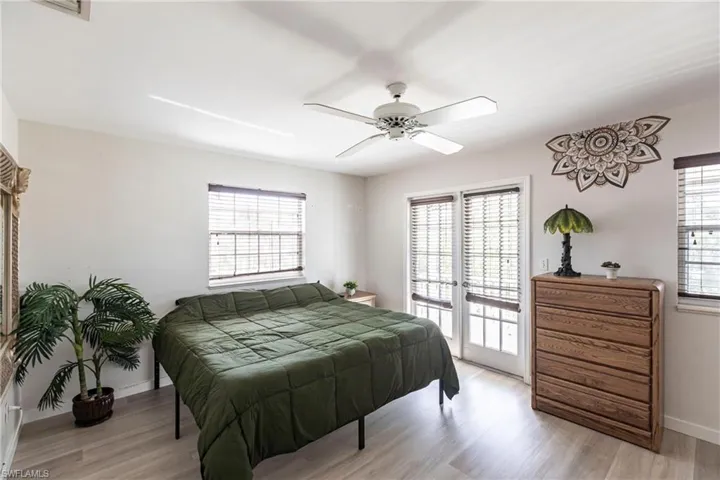 Bedroom with access to exterior, light wood-style flooring, and a ceiling fan