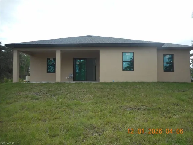 Back of property featuring stucco siding, a yard, a patio area, and roof with shingles
