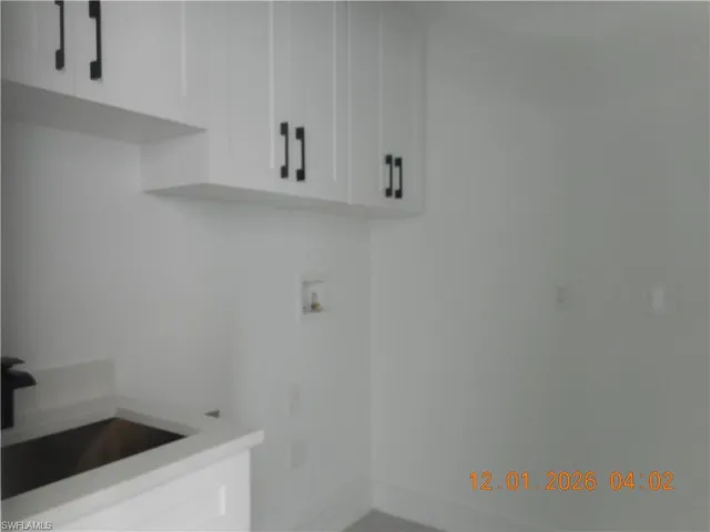Laundry area with washer hookup and cabinet space