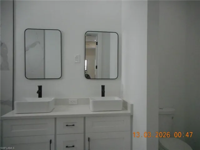 Bathroom featuring double vanity and toilet