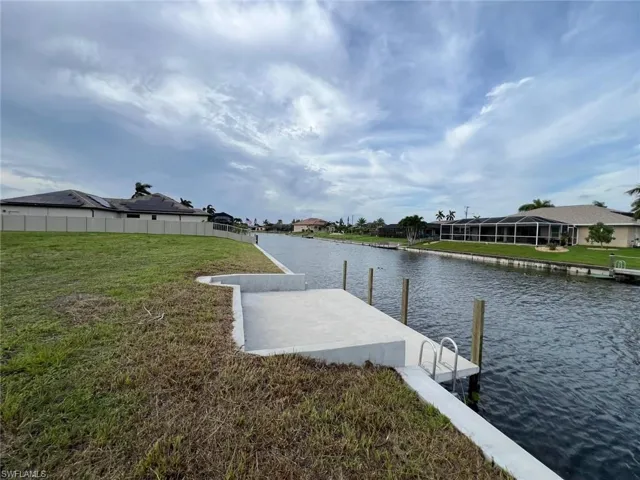 Dock area featuring a water view and a yard
