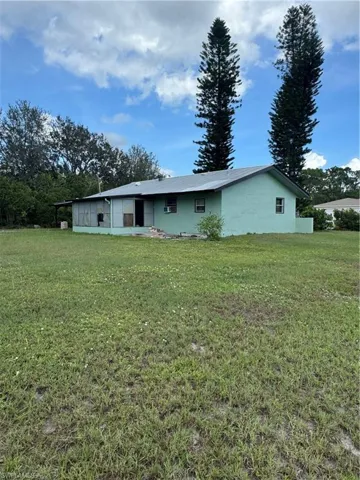 Rear view of property with a lawn