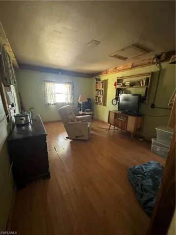 Den with hardwood / wood-style floors