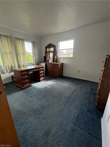 Carpeted bedroom featuring multiple windows