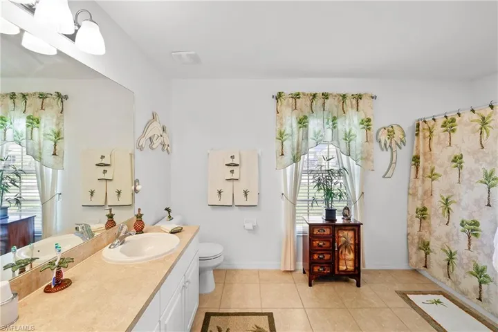 Bathroom featuring tile flooring, toilet, and large vanity