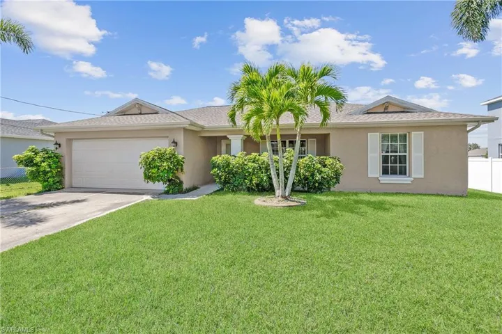 Single story home with a front yard and a garage