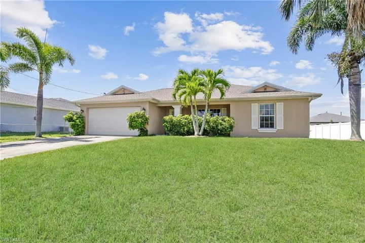 Single story home with a garage and a front yard