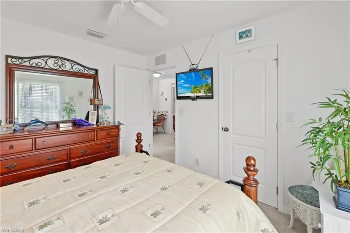 Bedroom with ceiling fan and light carpet