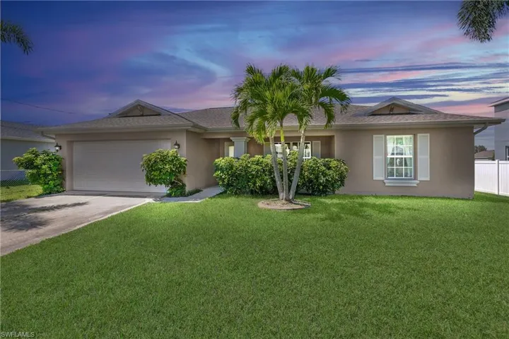 Ranch-style house with a garage and a lawn