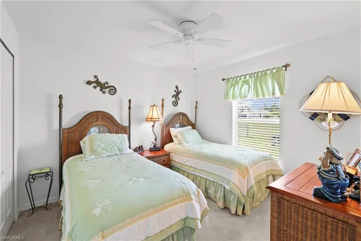 Carpeted bedroom featuring ceiling fan
