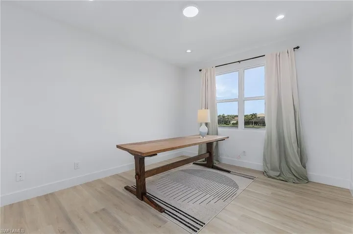 Guest Bedroom being used as an office featuring light hardwood / wood-style floors