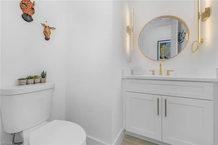 Bathroom featuring wood-type flooring, vanity, and toilet