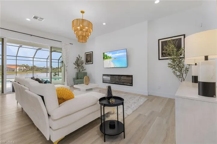 Living room with a chandelier and light hardwood / wood-style flooring