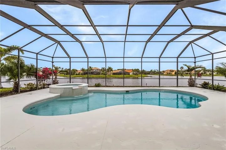 View of pool featuring a patio, a large lanai, an in ground hot tub, and a lake view