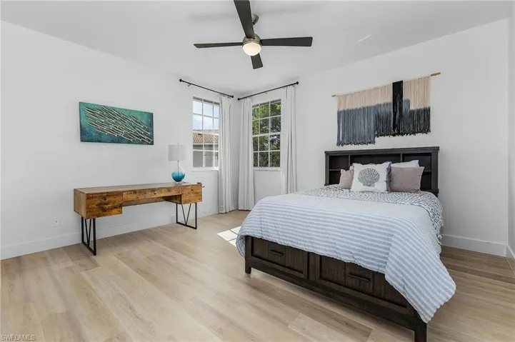 Bedroom with light hardwood / wood-style floors and ceiling fan