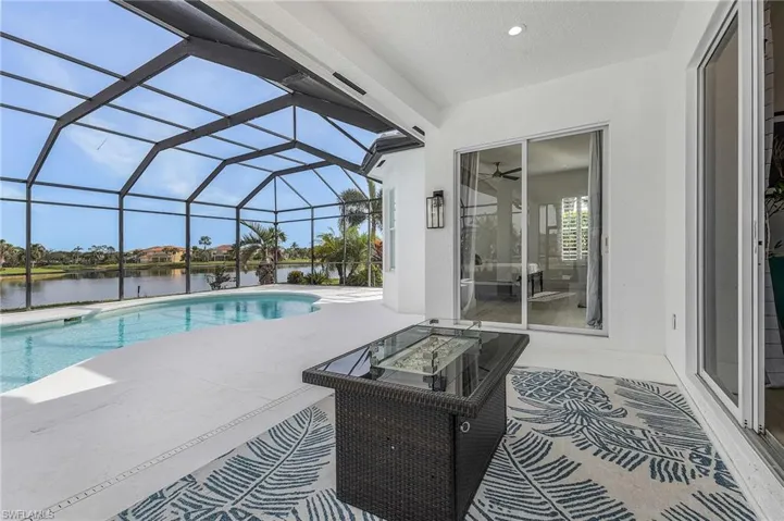 View of swimming pool featuring a patio, a water view, and large lanai.