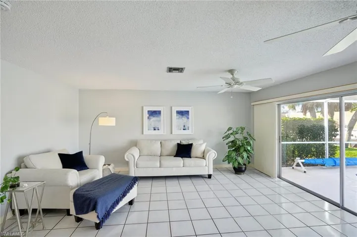 Spacious Living Room with Sliders to Screened Lanai overlooking the Pool & Canal
