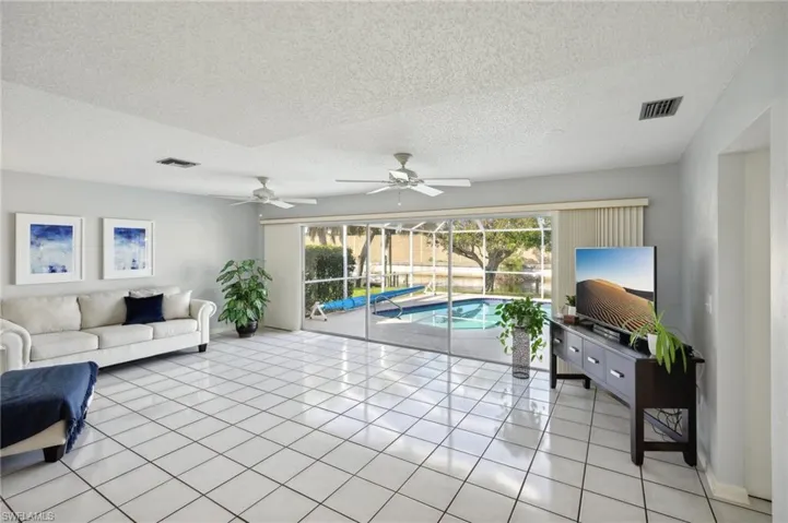 Spacious Living Room with Sliders to Screened Lanai overlooking the Pool & Canal