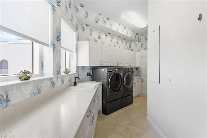 Amazing laundry room with sink and lots of natural light and storage.