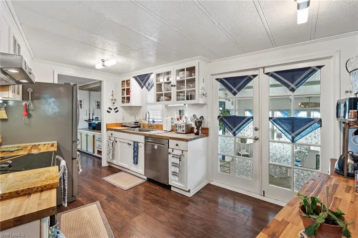 Kitchen featuring white cabinetry, appliances with stainless steel finishes, sink, and wooden counters
