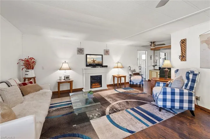 Living room with dark wood-type flooring and ceiling fan