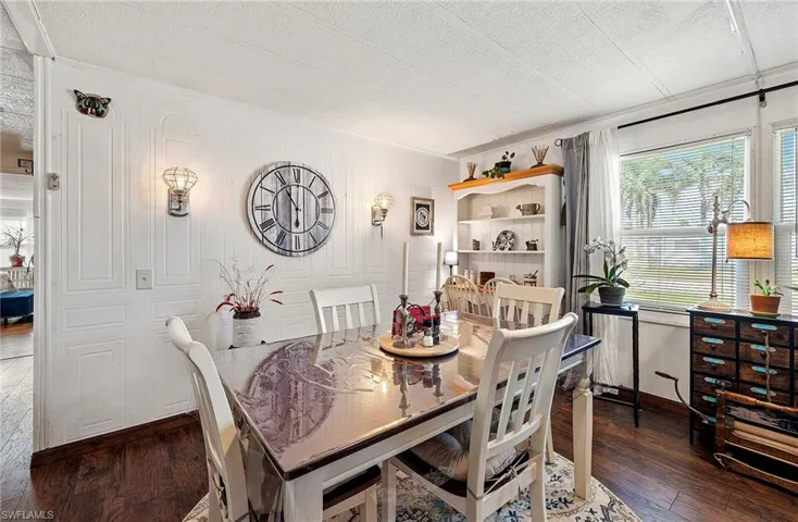 Dining space with dark hardwood / wood-style floors and a textured ceiling