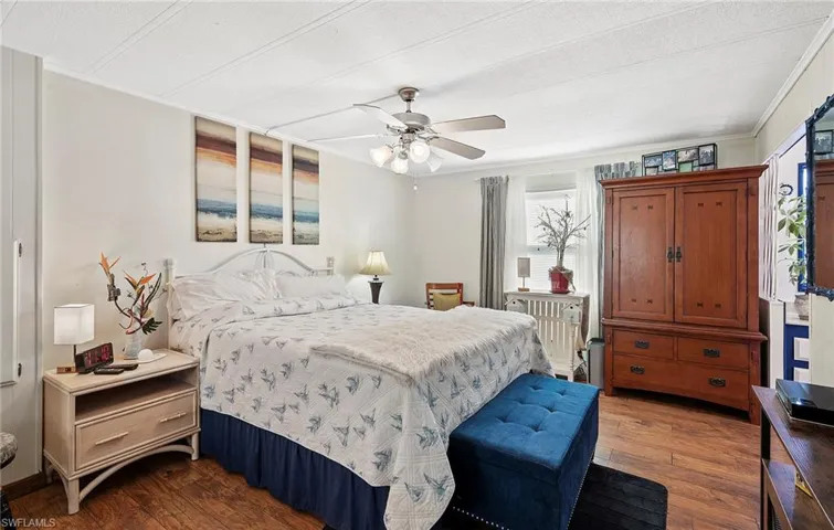 Bedroom featuring crown molding, radiator heating unit, ceiling fan, and dark hardwood / wood-style flooring
