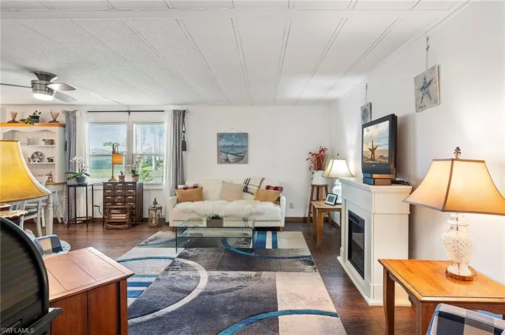 Living room with dark wood-type flooring and ceiling fan