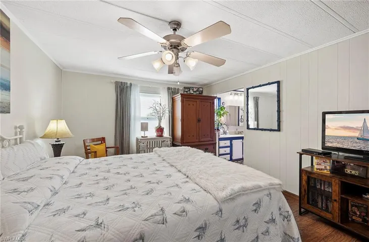 Bedroom featuring crown molding, dark hardwood / wood-style floors, and ceiling fan