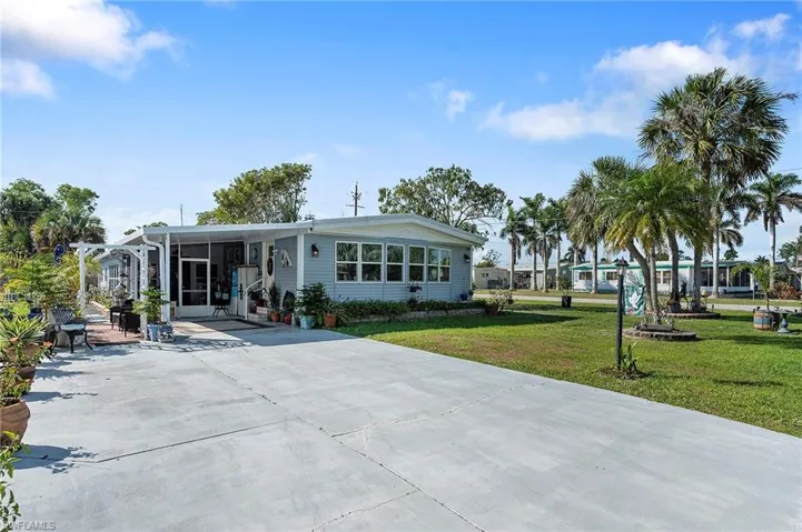 Manufactured / mobile home featuring a carport and a front lawn