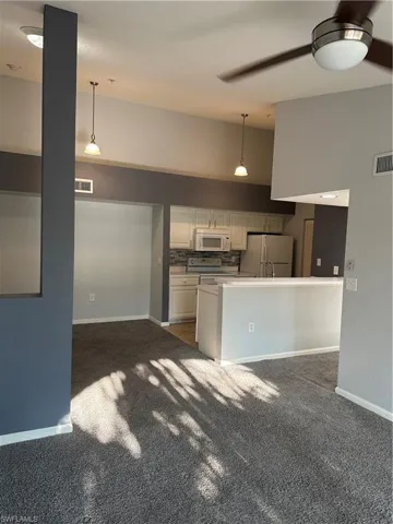 Vaulted ceilings with a ceiling fan, recessed lighting, and pendant lights