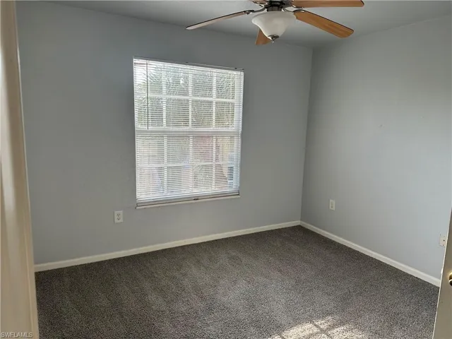Wall-to-wall carpeting, window with horizontal blinds, and ceiling fan with integrated lighting