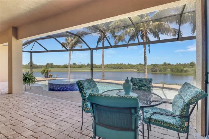View of patio featuring a water view, a pool with connected hot tub, and a lanai