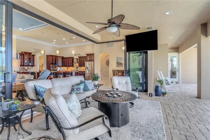 Living room featuring arched walkways, a ceiling fan, recessed lighting, crown molding, and a textured ceiling