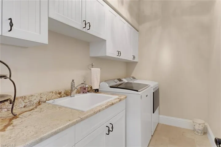 Washroom featuring cabinet space and washer and dryer