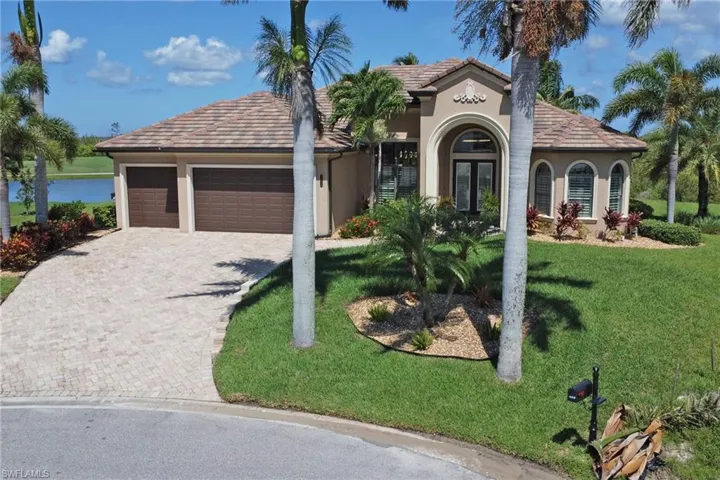 Mediterranean / spanish-style house with stucco siding, a garage, decorative driveway, and a front lawn