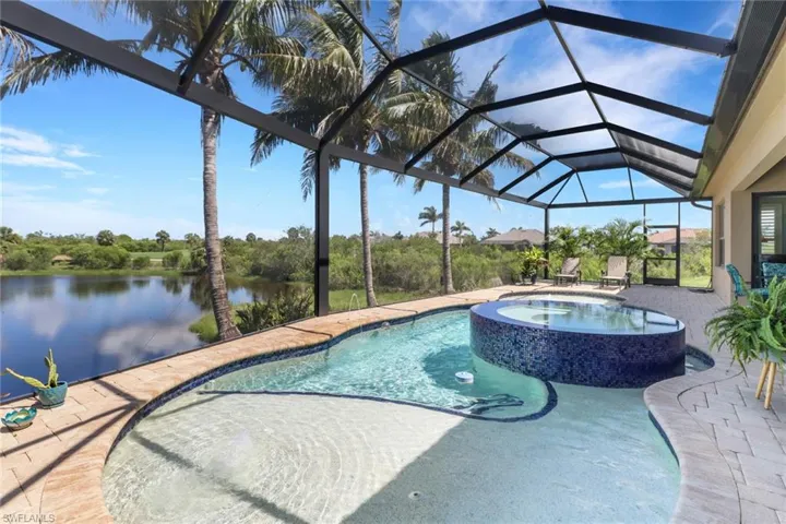 View of swimming pool with a patio area, a pool with connected hot tub, and a water view