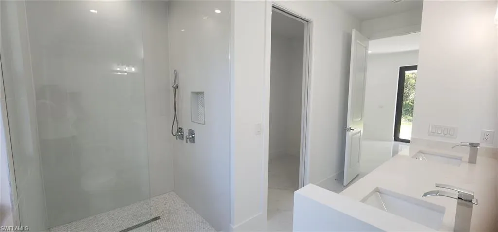Bathroom featuring vanity and a tile shower and walk in closet