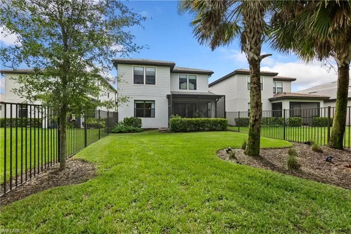 Back of property with a fenced backyard and a sunroom