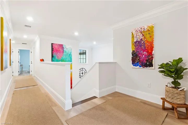 Hall featuring an upstairs landing, ornamental molding, wood finished floors, and recessed lighting